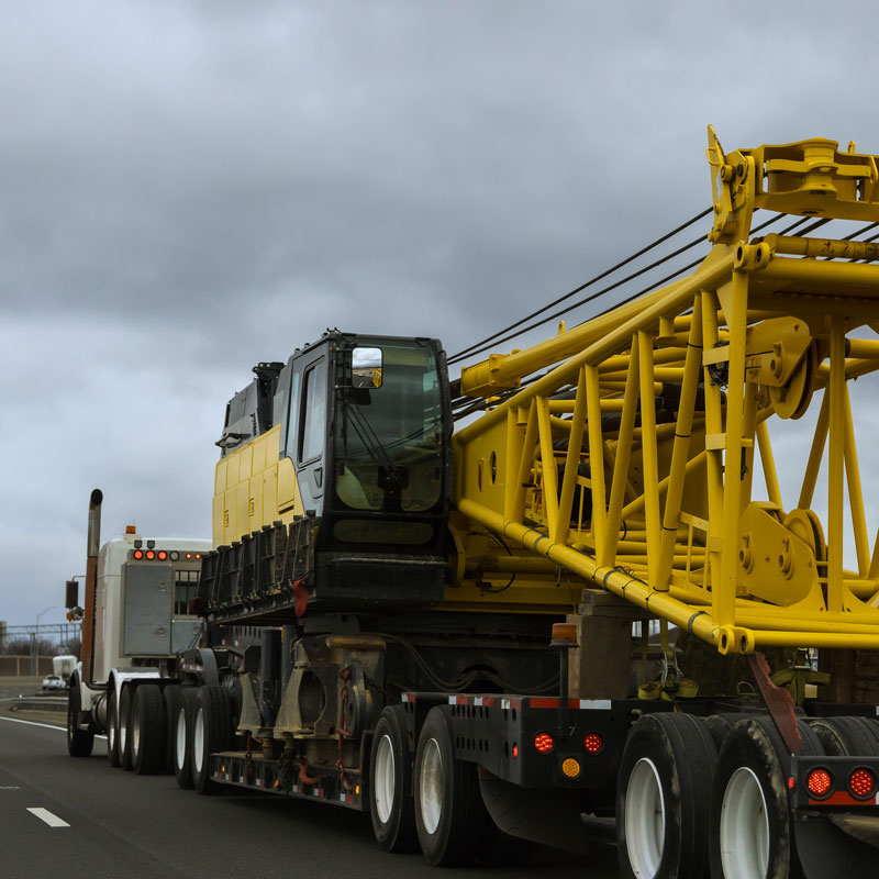 large truck hauling heavy construction equipment on highway